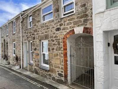 a stone building with a gate on a street at Treholme, great space for a family beach holiday! in St Ives