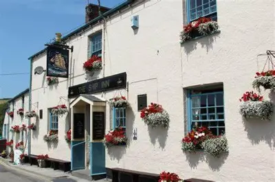 a white building with flower boxes on the side of it at Lime Kiln Cottage, Pentewan, Cornwall in Pentewan