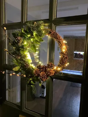 a wreath on a window with christmas lights at Lime Kiln Cottage, Pentewan, Cornwall in Pentewan
