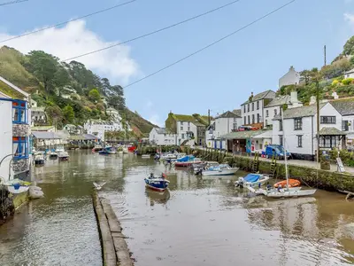 a group of boats in a river in a town at Laity in Polperro