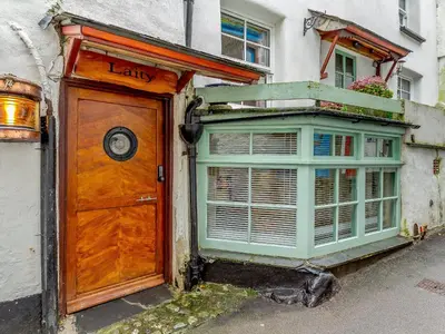 a building with a wooden door and a window at Laity in Polperro