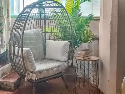 a bird cage with a chair and a plant at Laity in Polperro