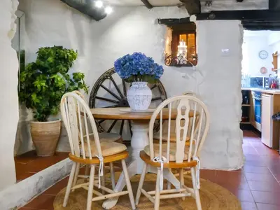a table with two chairs and a vase with blue flowers at Laity in Polperro