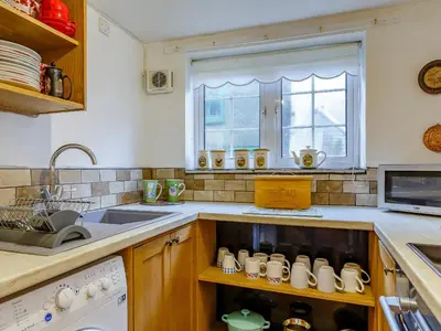 a kitchen with a sink and a counter with mugs at Laity in Polperro