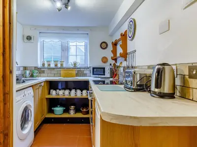 a kitchen with a washer and dryer on a counter at Laity in Polperro