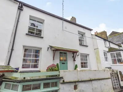 a white house with a green door at Talland House in Polperro