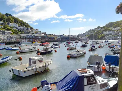 a bunch of boats are docked in a harbor at Talland House in Polperro