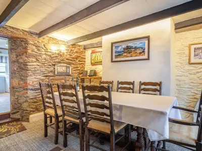 a dining room with a table and chairs at Talland House in Polperro