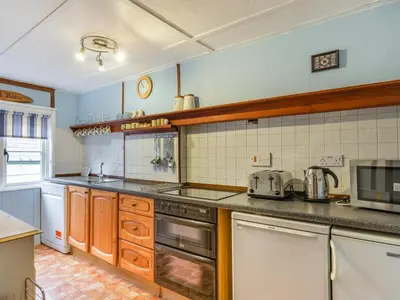 a kitchen with a stove and a counter top at Talland House in Polperro
