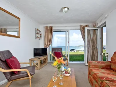 a living room with a view of the ocean at Apartment 2 Waters Edge in Crantock