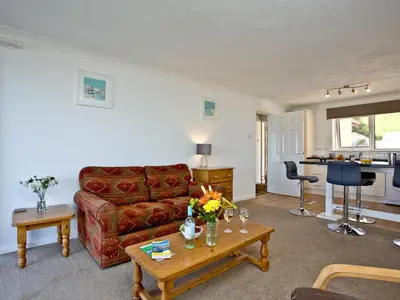 a living room with a couch and a table at Apartment 2 Waters Edge in Crantock