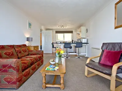 a living room with a couch and a table at Apartment 2 Waters Edge in Crantock