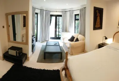 a living room with a bed and a couch at The Black Palms - Fistral Beach in Newquay