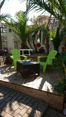 two green chairs and a table on a wooden deck at The Black Palms - Fistral Beach in Newquay