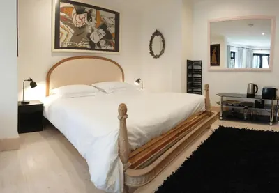 a bedroom with a large white bed and a mirror at The Black Palms - Fistral Beach in Newquay