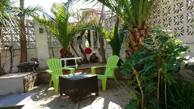 two green chairs and a table on a patio at The Black Palms - Fistral Beach in Newquay