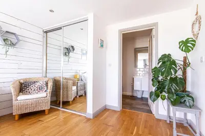 a living room with a glass door leading to a bedroom at Sea views, Cornwall, Portreath, hot tub, sauna in Portreath