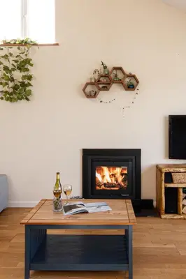 a living room with a fireplace and a table at Sea views, Cornwall, Portreath, hot tub, sauna in Portreath