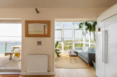 a living room with a couch and a mirror at Sea views, Cornwall, Portreath, hot tub, sauna in Portreath