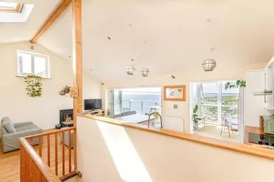 a staircase in a house with a view of the ocean at Sea views, Cornwall, Portreath, hot tub, sauna in Portreath