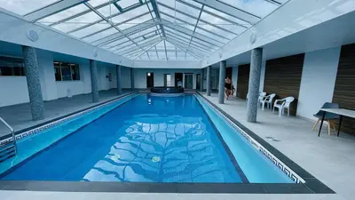 a large swimming pool in a building with a ceiling at Chalet 26 Widemouth Bay in Bude