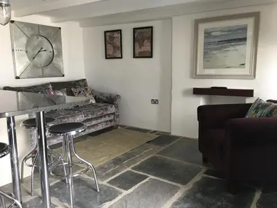 a living room with a couch and a table at The Padstow Cottage - Coswarth House in Padstow