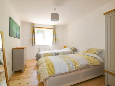 a bedroom with two beds and a window at The Cart House in St Austell