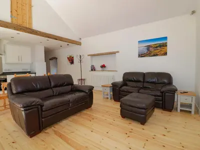 a living room with two leather couches and a table at The Cart House in St Austell