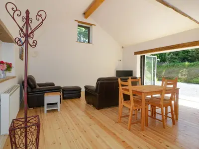 a living room with a table and a couch at The Cart House in St Austell
