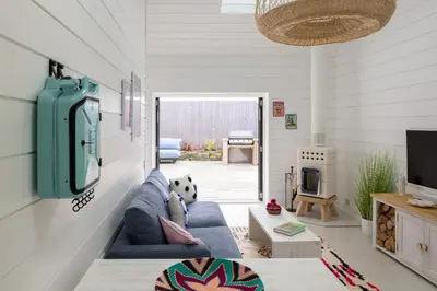 a living room with a blue couch and a tv at Three Mile Beach in Hayle
