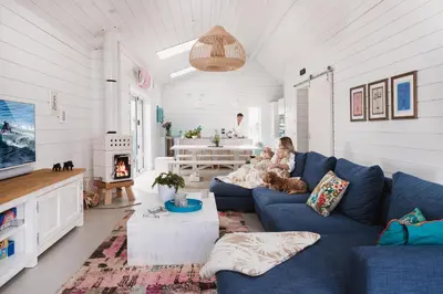 a woman and two children sitting on a couch in a living room at Three Mile Beach in Hayle