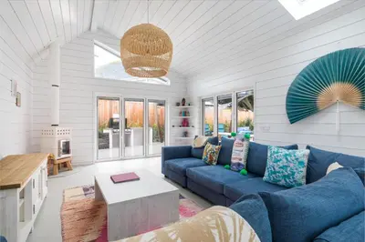 a living room with a blue couch and a table at Three Mile Beach in Hayle