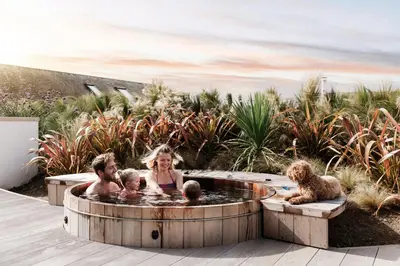 a woman with three children in a hot tub at Three Mile Beach in Hayle
