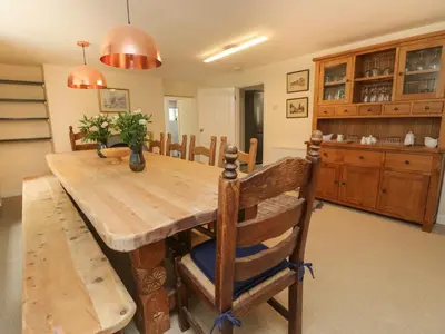 a dining room with a wooden table and chairs at 9 Copes Gardens in Truro