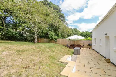 a patio with a table and chairs in a yard at 9 Copes Gardens in Truro