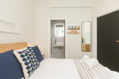 a bedroom with a bed with blue and white pillows at White Waves in St Ives