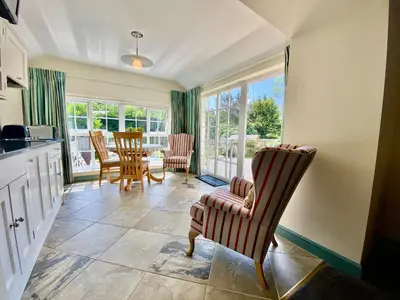 a kitchen with chairs and a dining room with a table at Lynwood House Self Contained Studio in Tregoney