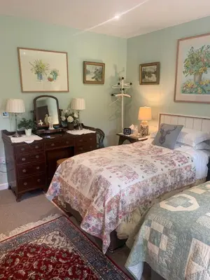 a bedroom with two beds and a dresser and a mirror at The Old Deer House in Bodmin