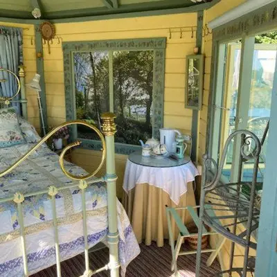 a bedroom with a bed and a table and a window at The Old Deer House in Bodmin