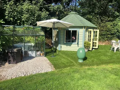 a green gazebo with a green egg in the grass at The Old Deer House in Bodmin