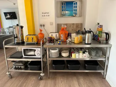 a kitchen with a cart with a microwave on it at Blue Room Hostel Newquay in Newquay