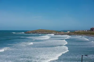 a row of waves on a beach with at Fistral Beach Penthouse, Newquay in Crantock