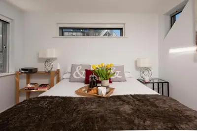a bedroom with a bed with a tray with flowers on it at Fistral Beach Penthouse, Newquay in Crantock