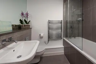 a bathroom with a sink and a toilet and a shower at Fistral Beach Penthouse, Newquay in Crantock