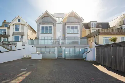 a large white house with a lot of windows at Fistral Beach Penthouse, Newquay in Crantock