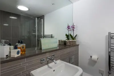 a bathroom with a sink and a mirror at Fistral Beach Penthouse, Newquay in Crantock
