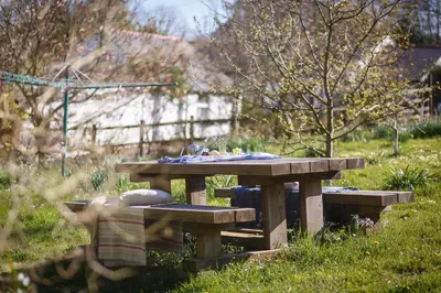 a picnic table and bench in the grass at The Snug at Cornish Barn Holidays in Truro