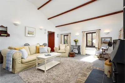 a living room with a couch and a table at The Snug at Cornish Barn Holidays in Truro