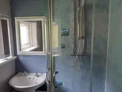 a bathroom with a sink and a shower at Admirals Apartment 'As seen in Beyond Paradise ' sleeps 6 adults in Looe