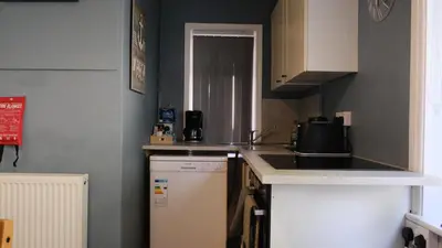 a small kitchen with a sink and a refrigerator at Admirals Apartment 'As seen in Beyond Paradise ' sleeps 6 adults in Looe